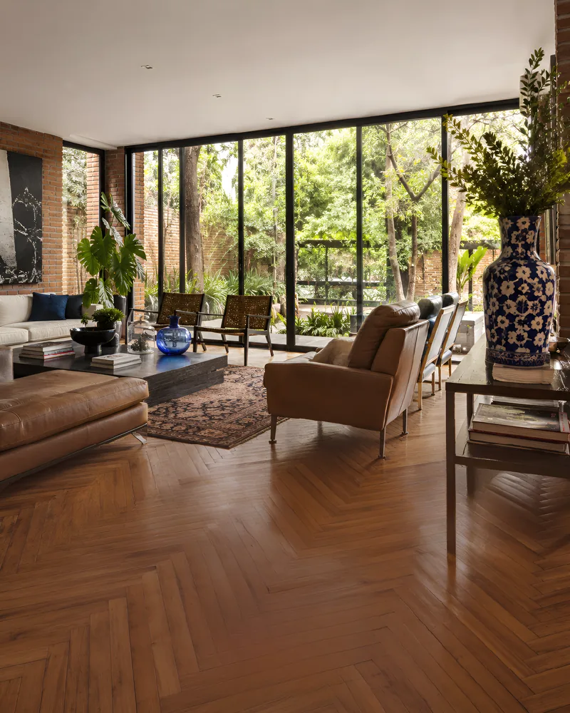 Sala abierta al jardín con piso de madera en espiga